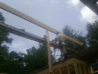 Carpenter setting a ridge beam over a new addition frame — Ice Dam Removal by Roofing Brothers in Church Hill