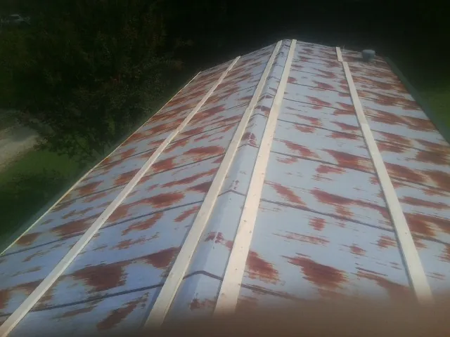 Rusted metal roof panels with new wood purlins before replacement — Storm Damage Roof Repair in Church Hill by Roofing Brothers